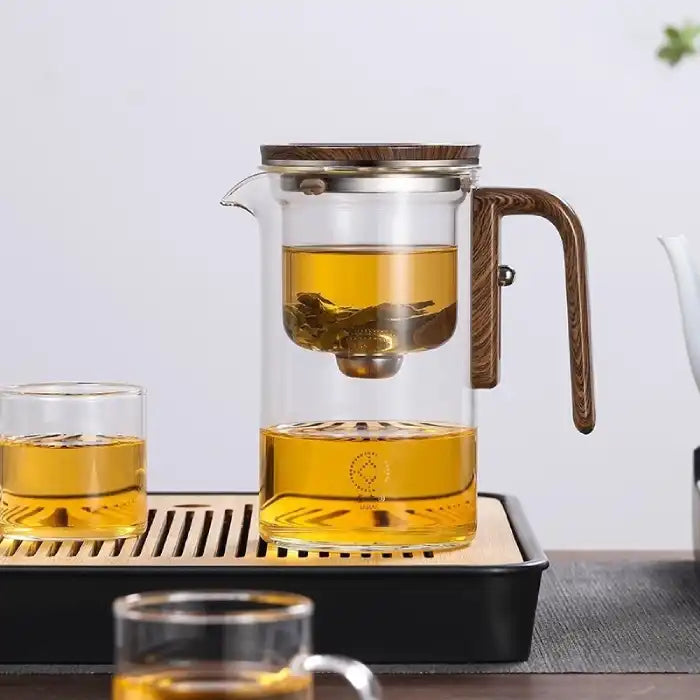  Glass Teapot with One-Click Magnetic Tea Infuser and cups on serving tray with modern tea setup.