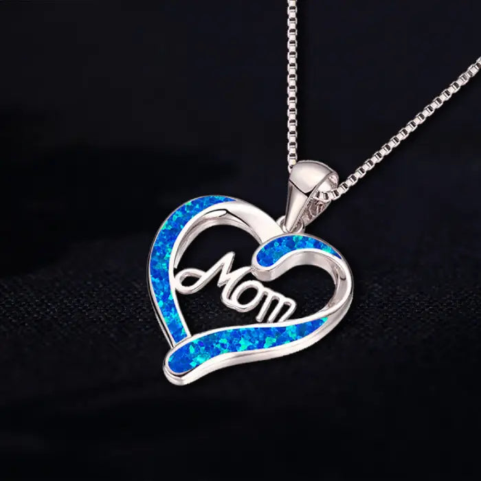 Elegant mom heart necklace with blue opal inlay displayed on black surface, perfect sentimental gift.