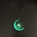 Glowing necklace featuring crescent moon and green glowing orb pendant on silver chain in darkness.