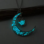 Glowing necklace with turquoise crescent moon and owl-shaped charm glowing in soft light.