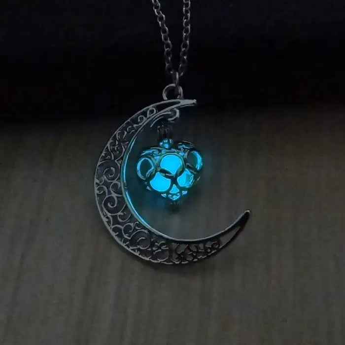 Glowing necklace featuring teal heart pendant and crescent moon design glowing gently in the dark.