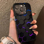 Glowing protective iPhone case with hexagonal pattern and blue-purple illuminated edges being held by hand with gold manicure