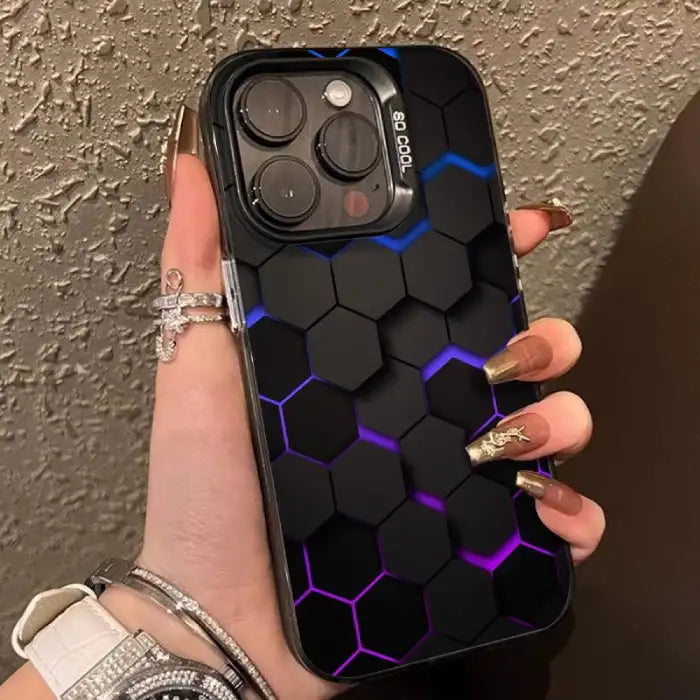 Glowing protective iPhone case with hexagonal pattern and blue-purple illuminated edges being held by hand with gold manicure