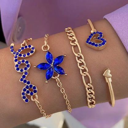 Elegant gold bracelet set with blue gemstone accents, including heart, flower, and “love” designs.