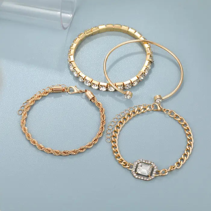 Flat display of gold bracelet set featuring crystal accents and various chain styles for elegant occasions.