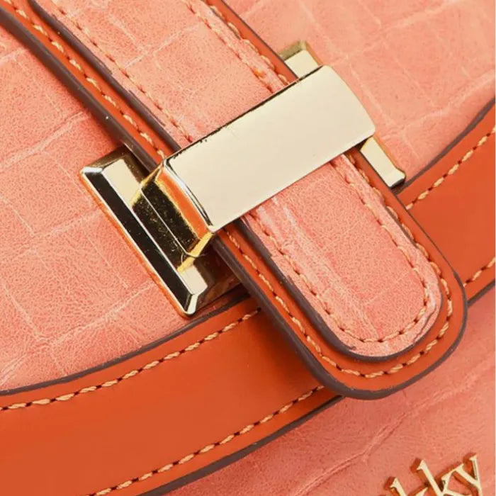 Detailed close-up of gold H-clasp hardware on coral croc-embossed leather with contrast stitching