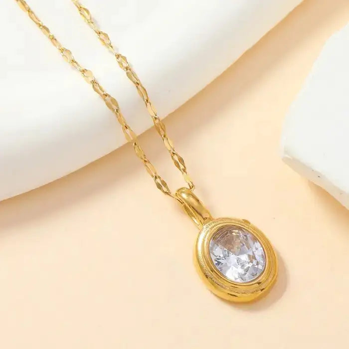 Gold oval pendant necklace with clear gemstone, a timeless and versatile accessory for any outfit.