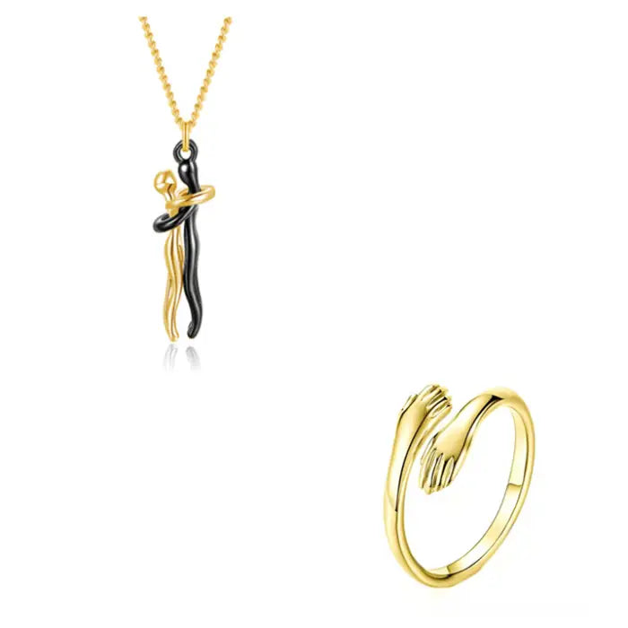 Gold couple hug pendant necklace and matching hand embrace ring in modern romantic jewelry collection.