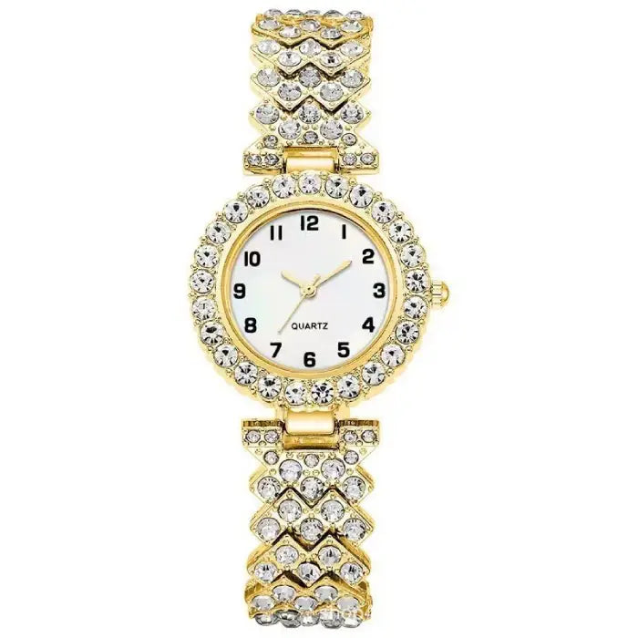 Gold quartz wristwatch with a white face and diamond like-studded band in a chevron design.