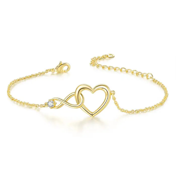 Simple and elegant gold heart infinity bracelet with a delicate chain and sparkling gemstone accent.