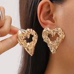 Gold heart Earrings chunky textured metal heart studs worn on ear