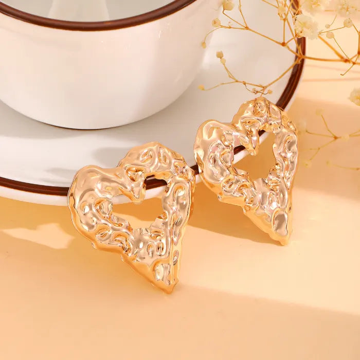 Gold heart Earrings luxury textured gold heart studs beside teacup