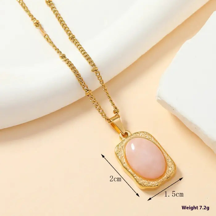 Gold rectangular pink stone pendant necklace with measurements for size, ideal for gift selection.