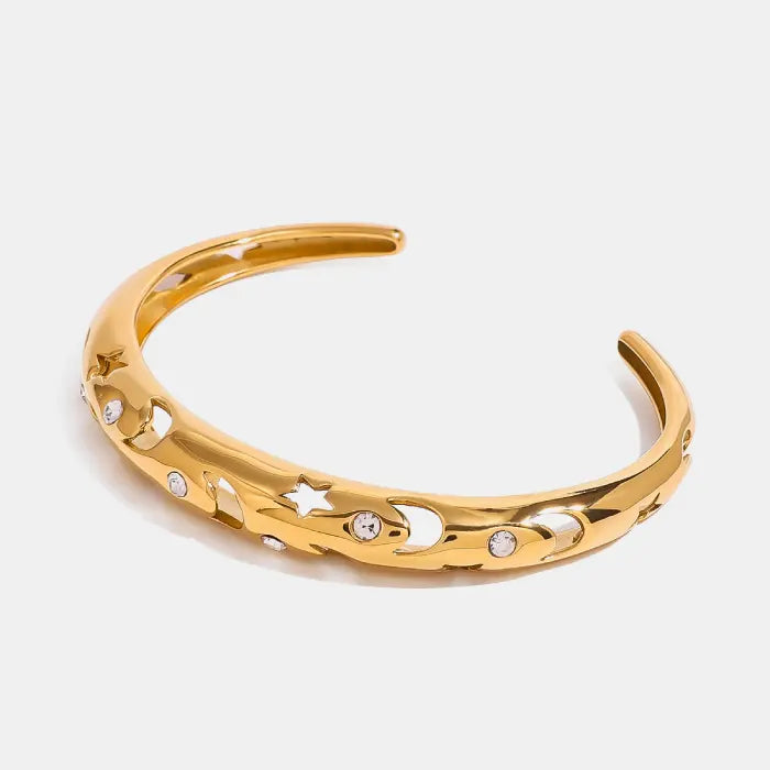 Gold plated bangle bracelet with moon and star design, featuring sparkling accents for a celestial jewelry look.