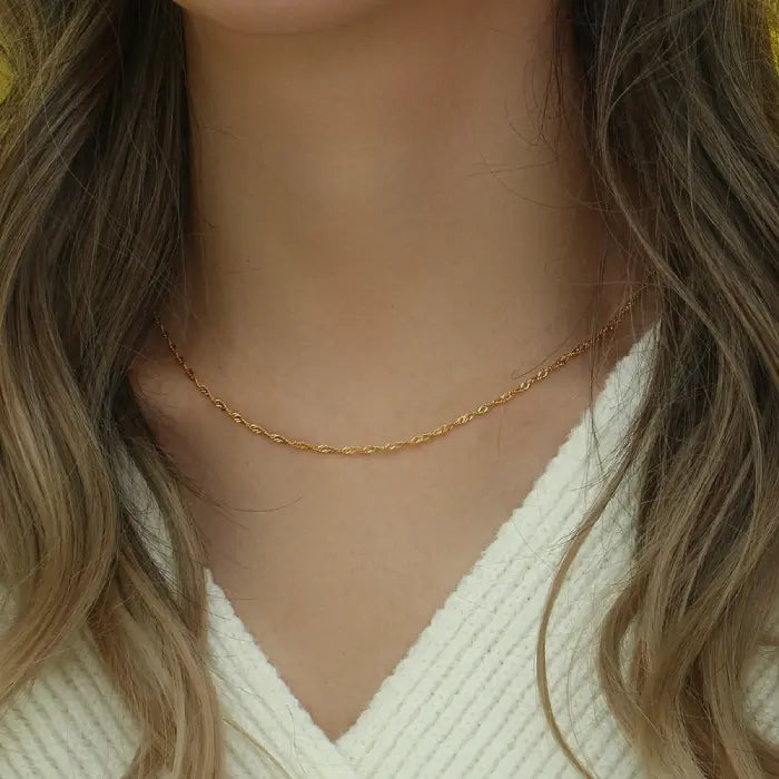 Closeup of a gold rope chain necklace on a neck, perfect for minimalist gold jewelry enthusiasts.