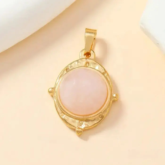 Gold round pendant with pink opal stone and delicate textured frame, ideal for elegant and minimal looks.