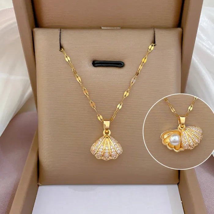 gold seashell necklace with crystal-studded shell pendant and pearl detail displayed in jewelry gift box