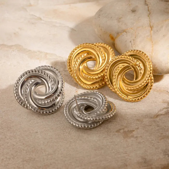 Gold and silver knot earrings displayed together on marble, offering versatile and stylish accessory options.