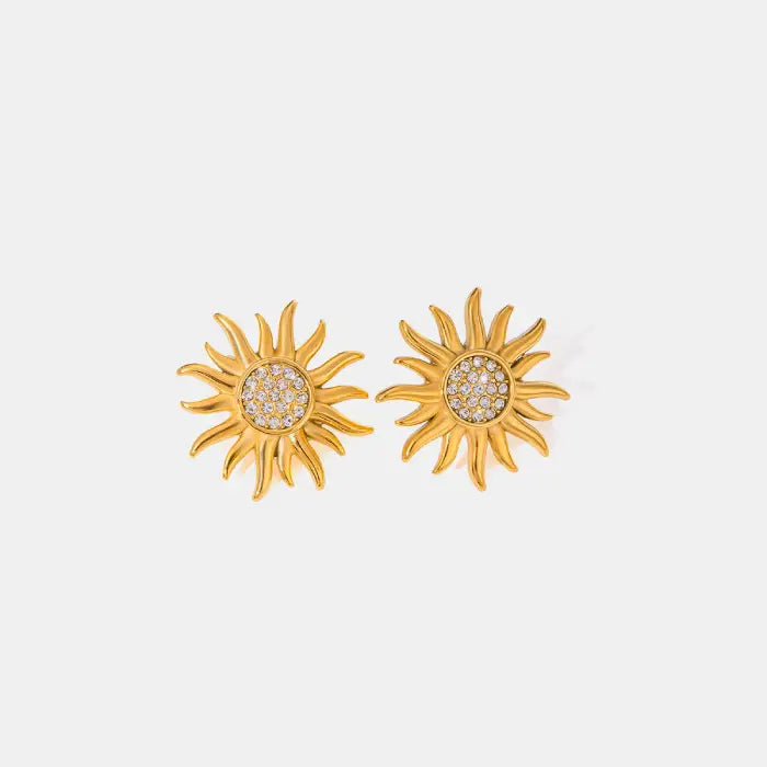 Gold sunburst stud earrings with rhinestone accents on a white background.