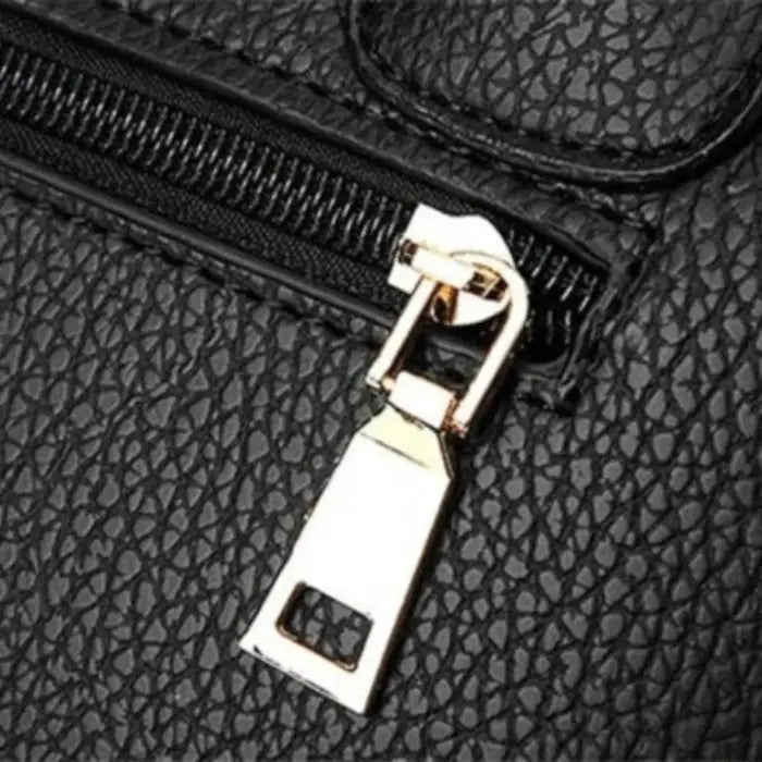 Close-up of gold zipper detail on black leather handbag, showcasing premium craftsmanship.