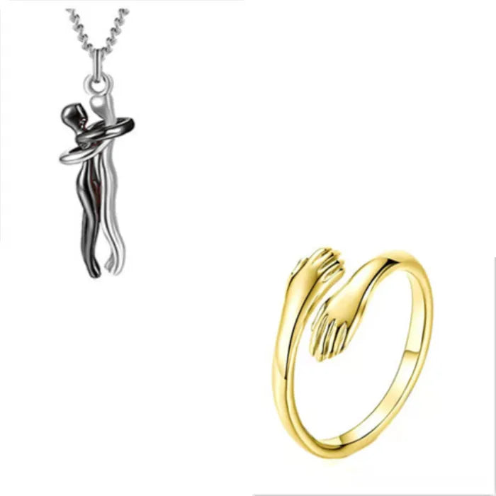 Elegant golden hands wrap ring alongside a silver couple embrace pendant necklace for stylish jewelry lovers.