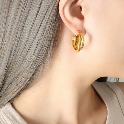 Golden hoop earring styled with ash grey hair and beige top showing everyday wear