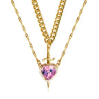 Gothic Heart Necklace in gold featuring a pink heart gemstone with dagger accent and layered chains.