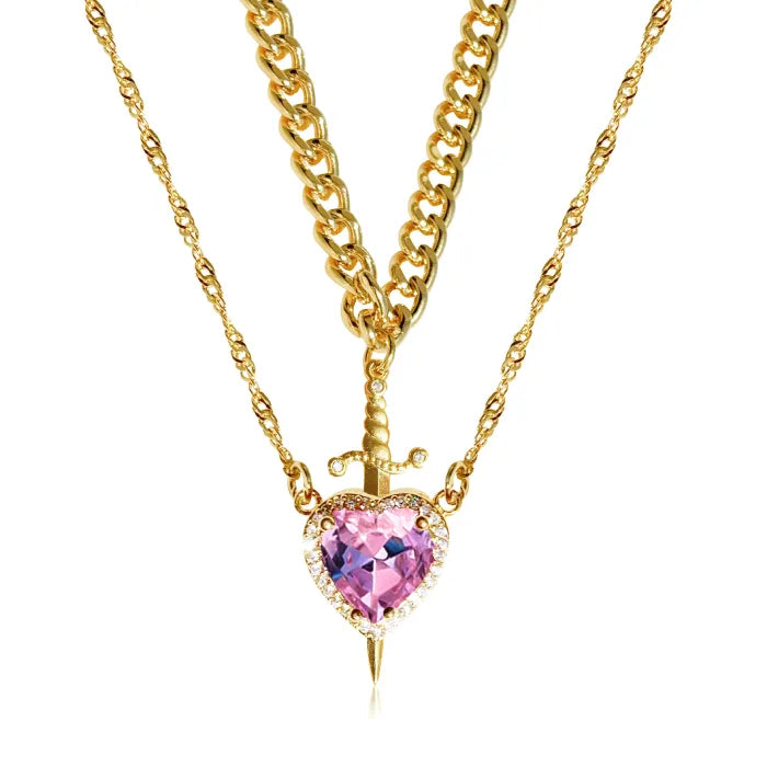 Gothic Heart Necklace in gold featuring a pink heart gemstone with dagger accent and layered chains.