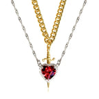 Gothic Heart Necklace combining gold and silver chains with striking red heart gemstone and dagger detail.