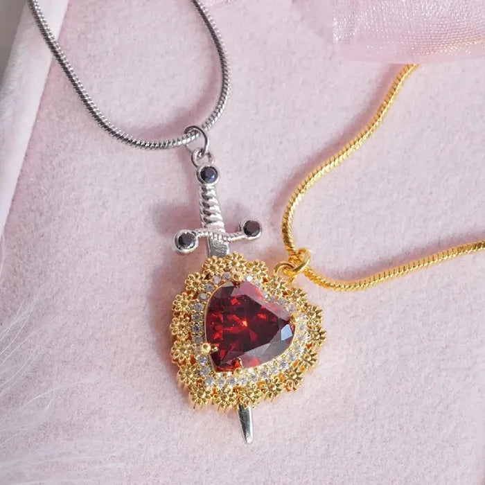 Gothic Heart Necklace with mixed metal chains and red gemstone heart paired with silver dagger pendant.