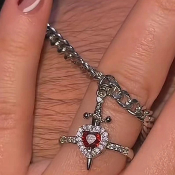 Gothic Heart Necklace charm with red gemstone heart displayed on finger with silver chain.