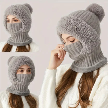 Three women wearing matching gray cable knit winter hats with pom poms and attached scarf face masks