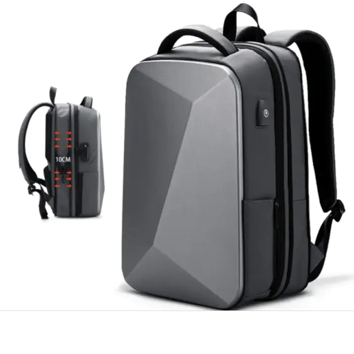 Gray expandable laptop backpack with angular design, showing dimensions and 10cm expansion capacity for 15.6 inch laptops