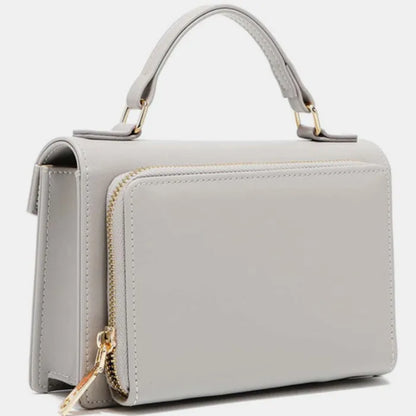 Side view of gray leather handbag showing zipper detail, structured shape, and top handle attachment