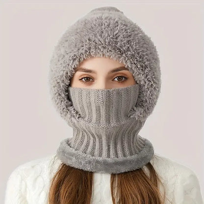 Person wearing a gray knit winter hat with faux fur trim that covers their face like a mask