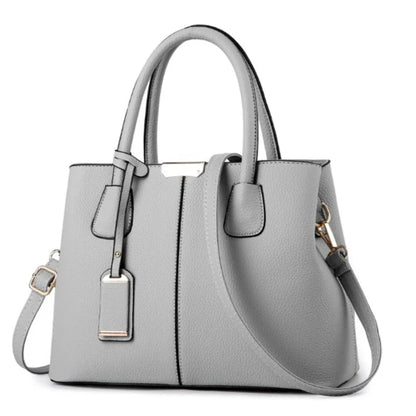 Versatile gray leather tote bag featuring gold hardware and adjustable strap for a modern look.