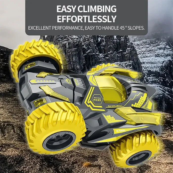 Gray and yellow stunt car climbing a steep rocky slope, showcasing excellent traction and performance.