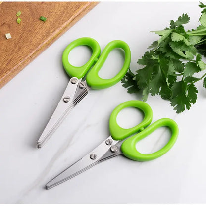 Two green-handled herb scissors placed near fresh parsley on a white surface with a wooden board.