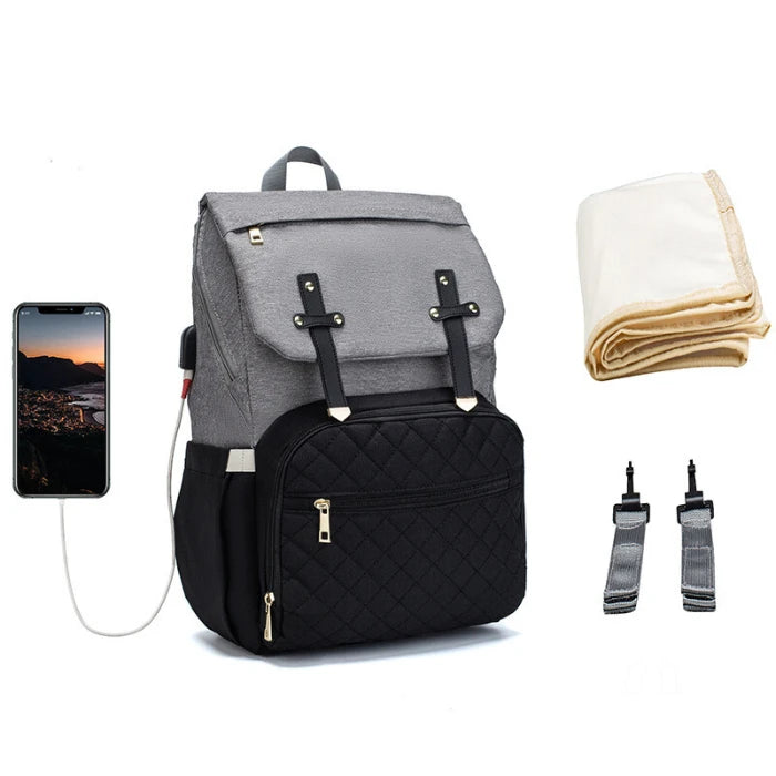 Two-tone diaper backpack with quilted pocket, USB charging capability and stroller attachment clips for modern parents