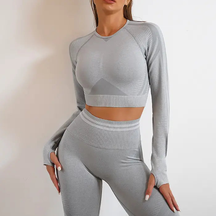  Women's grey seamless activewear set with long sleeves and high-waisted yoga leggings, front view.