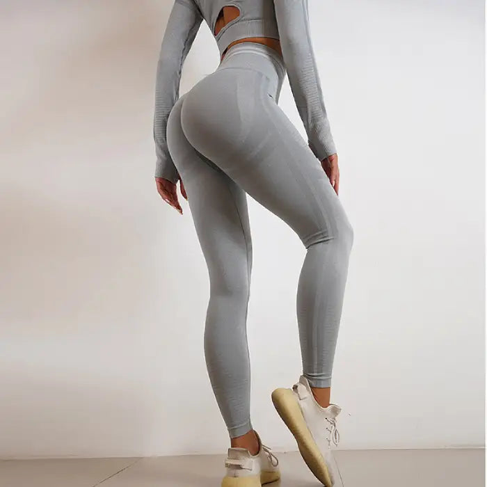 Seamless grey high-waisted yoga leggings and back cutout top for women’s activewear.