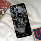Grunge skull phone case with yellow glowing eyes and textured black background, edgy and artistic.