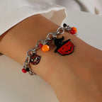 Costume jewelry Halloween bracelet with pumpkin and vampire charms on a wrist.