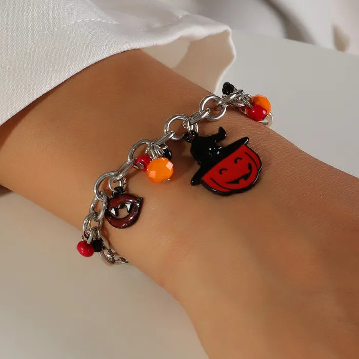 Costume jewelry Halloween bracelet with pumpkin and vampire charms on a wrist.