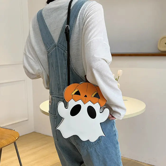 Halloween crossbody ghost bag worn over denim overalls, hanging at the back.