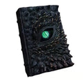 Halloween Decor book of dragons with textured black scales and green dragon eye on front cover.
