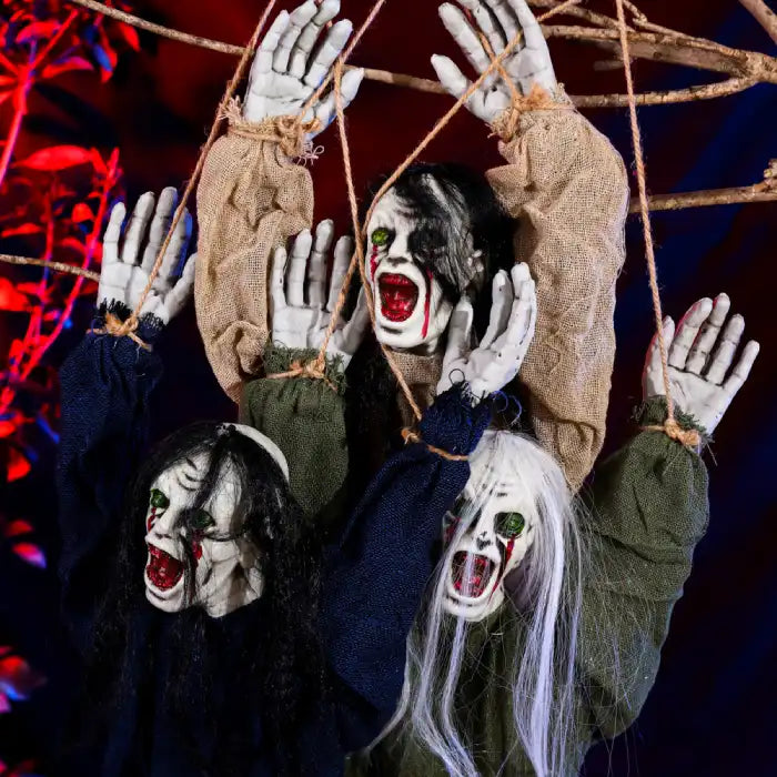 Halloween Decor Hanging Ghoul closeup showing terrifying faces with blood-red mouths and eerie green eyes.