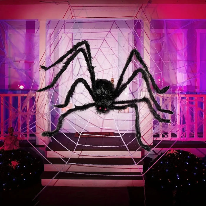 Halloween decoration black spider in large web on porch with purple lights and eerie atmosphere