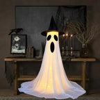 Halloween Ghost Yard Decor with long oval mouth and scared face glowing in Halloween home setting.