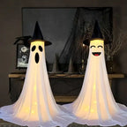 Halloween Ghost Yard Decor duo with light-up faces and witch hats inside spooky indoor display.